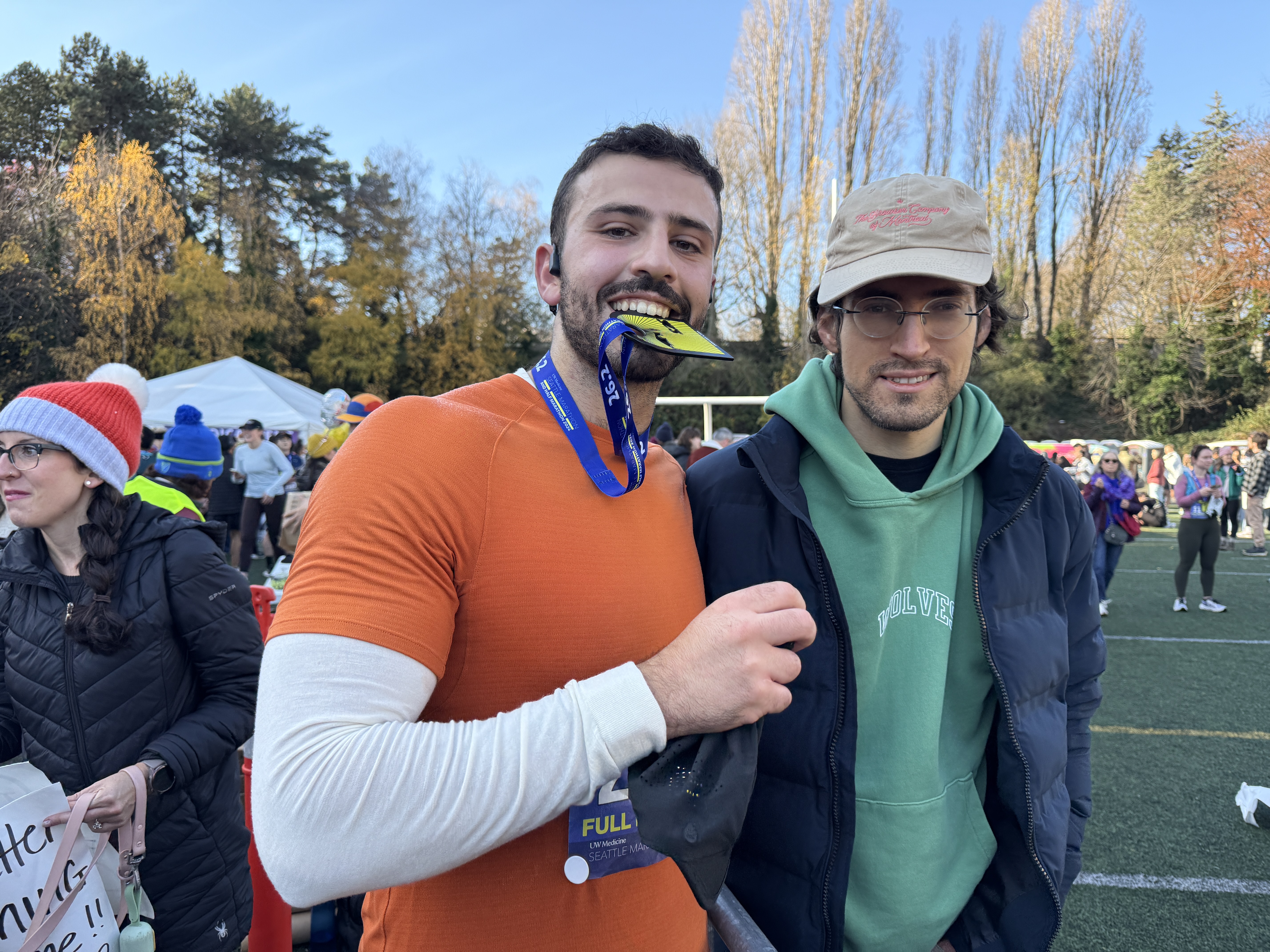 Marathon finisher with friend holding medal